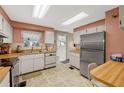 Galley kitchen with stainless steel appliances and light wood cabinets at 2010 Brookside Dr, Mount Dora, FL 32757