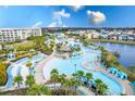 Aerial view of community pool surrounded by palm trees, cabanas, and lounge chairs, perfect for relaxation at 2904 On The Rocks Pt, Kissimmee, FL 34747