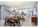 Spacious dining area with a wooden table and chairs, adjacent to a modern kitchen at 3092 Prelude Ln, Kissimmee, FL 34746