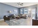 Cozy living room featuring a gray sectional sofa and a neutral rug at 3092 Prelude Ln, Kissimmee, FL 34746