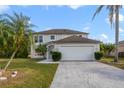 Two-story house with a two-car garage and a palm tree in the front at 3170 Santa Cruz Dr, Kissimmee, FL 34746