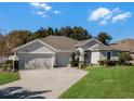 Single-story house with a two-car garage and lush green landscaping at 381 Skyview Pl, Chuluota, FL 32766