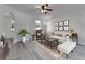 Bright living room featuring neutral walls, a ceiling fan, and light gray wood floors, perfect for entertaining guests at 381 Skyview Pl, Chuluota, FL 32766