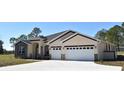 Tan house with dark brown accents, stone facade, and a two-car garage at 41289 County Road, 452, Leesburg, FL 34788