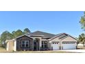 Tan house with dark brown accents, stone facade, and a two-car garage at 41289 County Road, 452, Leesburg, FL 34788