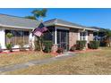 Brick house with American flag, landscaped yard, and walkway at 425 Iowa Woods E Cir, Orlando, FL 32824