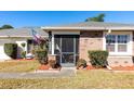 House exterior featuring a screened porch and landscaping at 425 Iowa Woods E Cir, Orlando, FL 32824