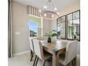 Dining area with light wood table, neutral decor, and stylish chandelier at 4418 Small Creek Rd, Kissimmee, FL 34744