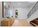 Welcoming foyer with modern decor, light wood floors, and staircase with black railings at 6564 Lagoon St, Windermere, FL 34786