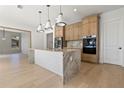 Modern kitchen with light wood cabinets, a large island with marble countertop and a stainless steel range at 6564 Lagoon St, Windermere, FL 34786