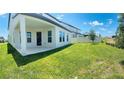 Expansive backyard with lush green grass, a covered patio, and a white fence offering privacy at 16337 Silver Grove Blvd, Winter Garden, FL 34787
