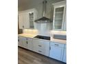 Modern kitchen with white cabinets, quartz countertops, subway tile backsplash, and stainless steel range hood at 16337 Silver Grove Blvd, Winter Garden, FL 34787