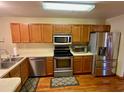Kitchen with stainless steel appliances and wood cabinets at 1938 Gamboge Dr, Orlando, FL 32822