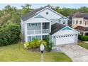 Two-story house with gray siding, teal accents, and a large backyard at 2119 Victoria Dr, Davenport, FL 33837