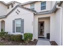 Charming home featuring a gray front door that is open to the interior, gray shutters, and landscaping at 236 Captiva Dr, Davenport, FL 33896