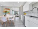 Bright kitchen featuring white cabinets, stainless steel appliances and view to living area at 2901 Primrose Ct, Orlando, FL 32803