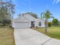 Gray house with a two-car garage and a palm tree at 604 Elfrida Way, Kissimmee, FL 34758