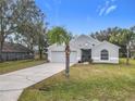 Gray house with a two-car garage and a palm tree at 604 Elfrida Way, Kissimmee, FL 34758