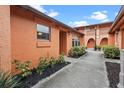 Exterior pathway showcasing building's orange facade and landscaping at 734 E Michigan St # 113, Orlando, FL 32806