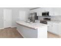 Modern kitchen with white cabinets, stainless steel appliances, and an island at 878 Galloway St, Lake Alfred, FL 33850