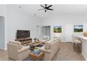 Bright living room with beige furniture, wood-look floors, and a large TV at 878 Galloway St, Lake Alfred, FL 33850