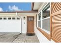 Close-up of the front entrance with a stylish door, brick walkway, and white garage door with windows at 8836 Ava Lake Dr, Orlando, FL 32810