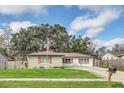 Inviting single-story home with a lush green lawn and a paved driveway leading up to the house at 8836 Ava Lake Dr, Orlando, FL 32810