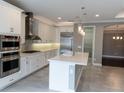 Modern kitchen with white cabinets, stainless steel appliances, and quartz countertops at 8876 Finsen St, Orlando, FL 32827