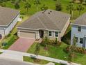 Well maintained single-story home, complemented by manicured lawn, mature landscaping, and a brick paved driveway at 1123 Happy Forest Loop, Deland, FL 32720