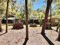 Spacious backyard with large trees and a wood pile at 12151 Se 86Th Ave, Belleview, FL 34420