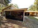 Relaxing screened porch with seating and access to backyard at 12151 Se 86Th Ave, Belleview, FL 34420