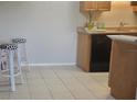 Kitchen with wood cabinets, black appliances, and tile floor at 1695 Lee Rd # A209, Winter Park, FL 32789