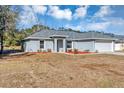 Gray house with a two-car garage and landscaping at 17 Walnut Crse, Ocala, FL 34480