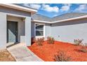 Gray front door with red mulch landscaping at 17 Walnut Crse, Ocala, FL 34480
