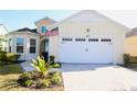 Inviting yellow home with a two-car garage and a neatly paved driveway at 240 Blue Starfish Pl, Daytona Beach, FL 32124