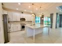 Modern kitchen with white cabinets, granite countertops, and stainless steel appliances at 240 Blue Starfish Pl, Daytona Beach, FL 32124