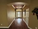 Inviting foyer with wood floors, arched entryways, and decorative chandelier at 2544 Ashville Ave, The Villages, FL 32162