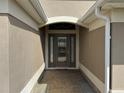 Inviting front entrance with decorative glass door and brick-paved walkway at 2544 Ashville Ave, The Villages, FL 32162