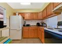 Kitchen with wood cabinets, white appliances, and ample counter space at 2858 N Powers Dr # 123, Orlando, FL 32818