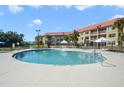 Community pool with lounge chairs and umbrellas at 6403 Parc Corniche Dr # 4309, Orlando, FL 32821