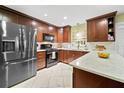 A modern kitchen featuring stainless steel appliances and beautiful custom wood cabinets at 9311 University Blvd, Orlando, FL 32817