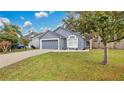 Gray house with a two-car garage and neatly landscaped yard at 100 Kelly Cir, Sanford, FL 32773