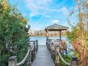 Wooden gazebo and dock on a lake with lush vegetation at 10125 Canopy Tree Ct, Orlando, FL 32836