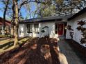 Updated home exterior boasts a red door and freshly mulched landscaping at 1461 Lancelot, Casselberry, FL 32707