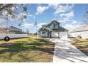 Green two-story house with attached garage and American flag at 2210 Kentucky Derby Dr, Orlando, FL 32825