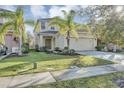 Two-story house with a two-car garage and palm trees at 2616 Santosh Cv, Kissimmee, FL 34746