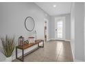 Bright entryway with tile flooring, a wooden bench, and a large mirror at 2662 Tahoe Ter, St Cloud, FL 34771