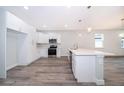 Open-concept kitchen with white shaker cabinets, island, and stainless steel appliances at 2909 S Palmetto Ave, Sanford, FL 32773