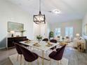 Bright dining room with a large table, chandelier, and stylish chairs at 3465 Middlebrook Pl, Harmony, FL 34773