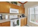 White appliances and light wood cabinets in this well-lit kitchen at 4765 Ormond Beach Way, Kissimmee, FL 34746